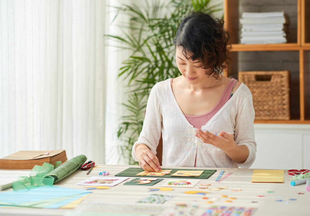 Talented Asian woman making greeting cards for her friends